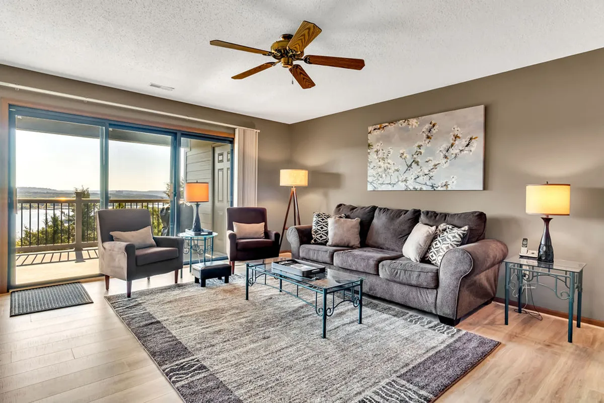 An elegant living area with a comfortable sofa and armchairs arranged to face a large window offering sweeping views. The mood is serene, with soft lighting and a sense of spaciousness—ideal for cozy mornings or sunset moments.